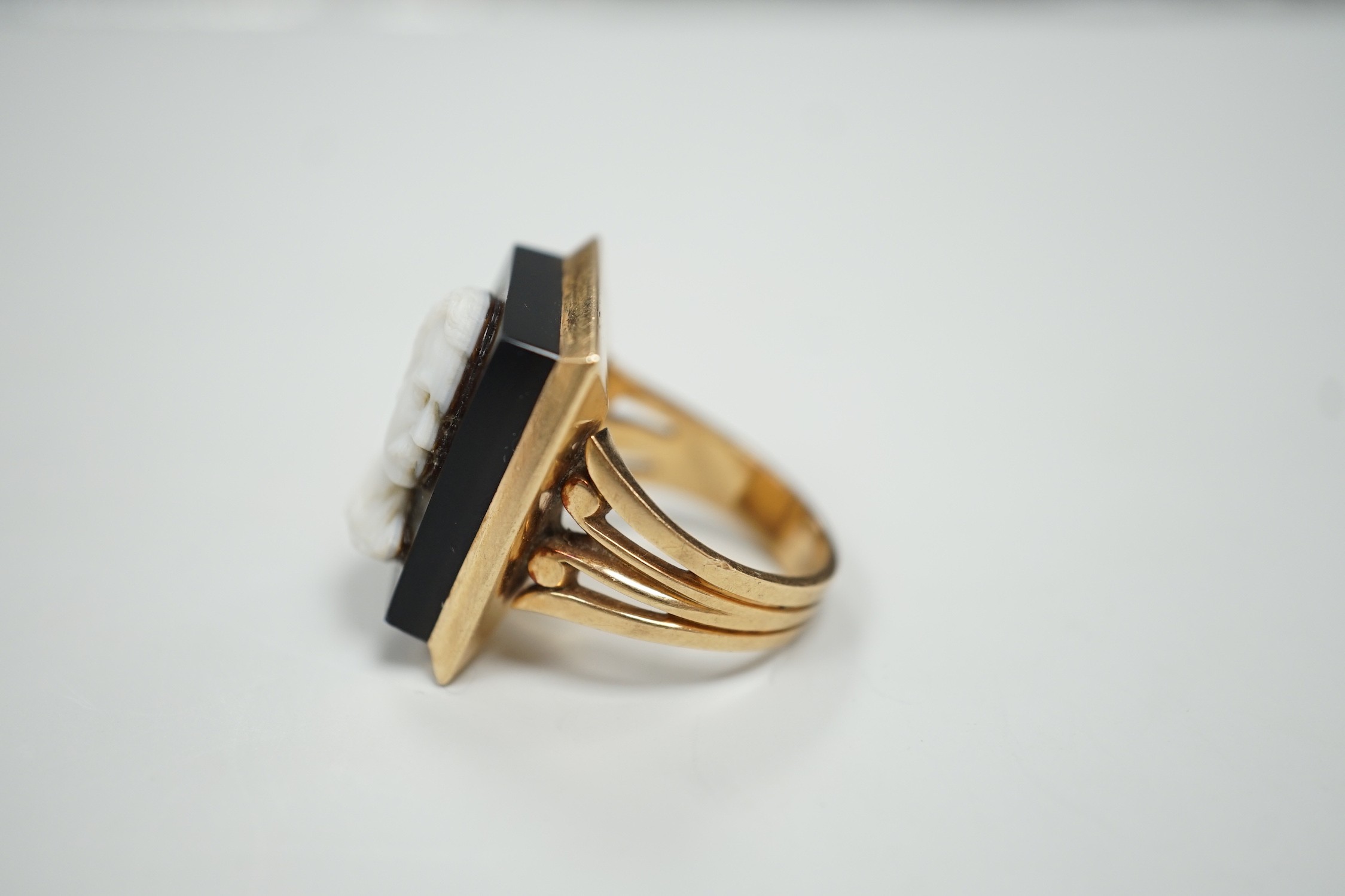 A yellow metal and black sardonyx set rectangular cameo ring, carved with the bust of a gentleman to sinister, size L, gross weight 12.6 grams.